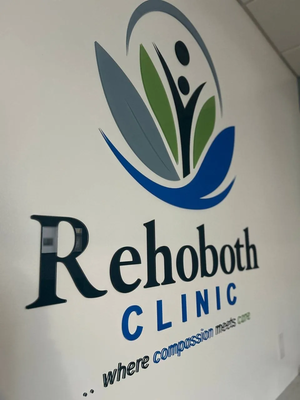 Rehoboth Clinic dimensional lobby logo and name with the tagline where compassion meets care